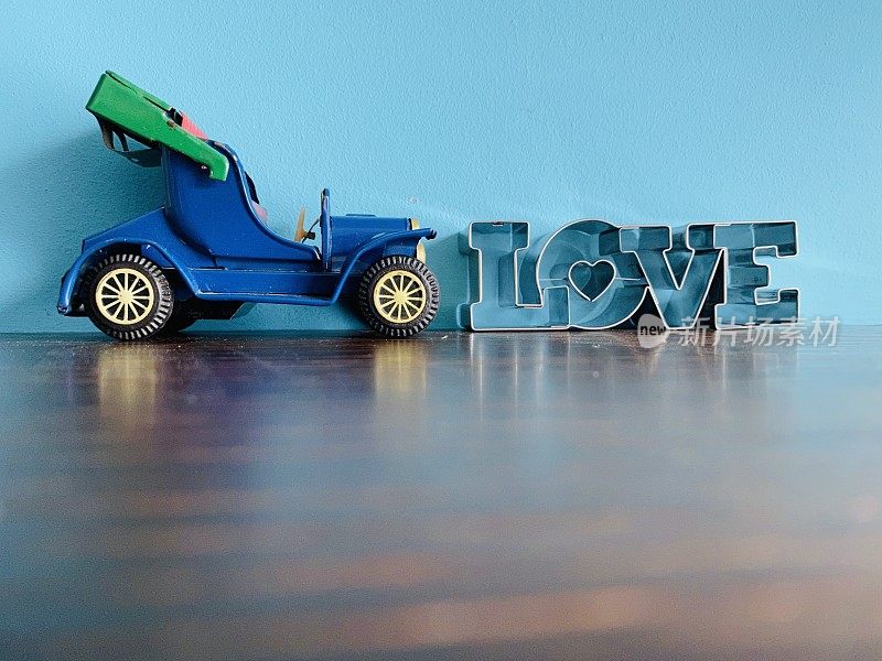 Word LOVE和蓝色背景的可转换玩具车